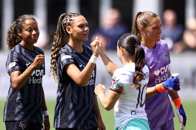 WASHINGTON, DC - AUGUST 25: Casey Krueger #3, Trinity Rodman #2 and Aubrey Kingsbury #1 of Washington Spirit greet Lo'eau LaBonta #10 of Kansas City Current at Audi Field on August 25, 2024 in Washington, DC. (Photo by Tim Nwachukwu/Getty Images)
